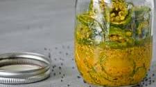 Pickled jalapeños in ground mustard seeds and turmeric powder