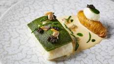 Herb-crusted turbot with hasselback potatoes, clams and butter sauce