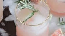 grapefruit gin fizz cocktail with rosemary garnish