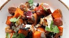 Roasted sweet potatoes, onions and nuts salad, topped with goat cheese